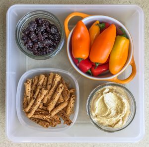 Healthy work snacks dried cherries, sweet peppers, hummus, tortilla chips