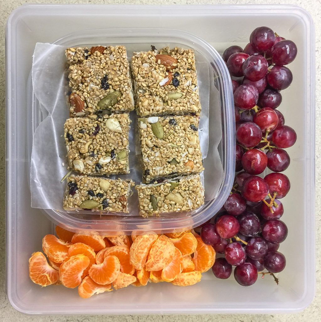 Healthy work snacks granola bars, grapes, mandarins