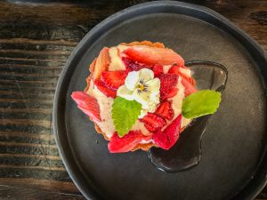 A round black plate with a strawberry rhubarb tart