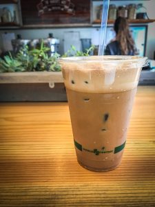 An iced coffee drink sitting on a wooden bar