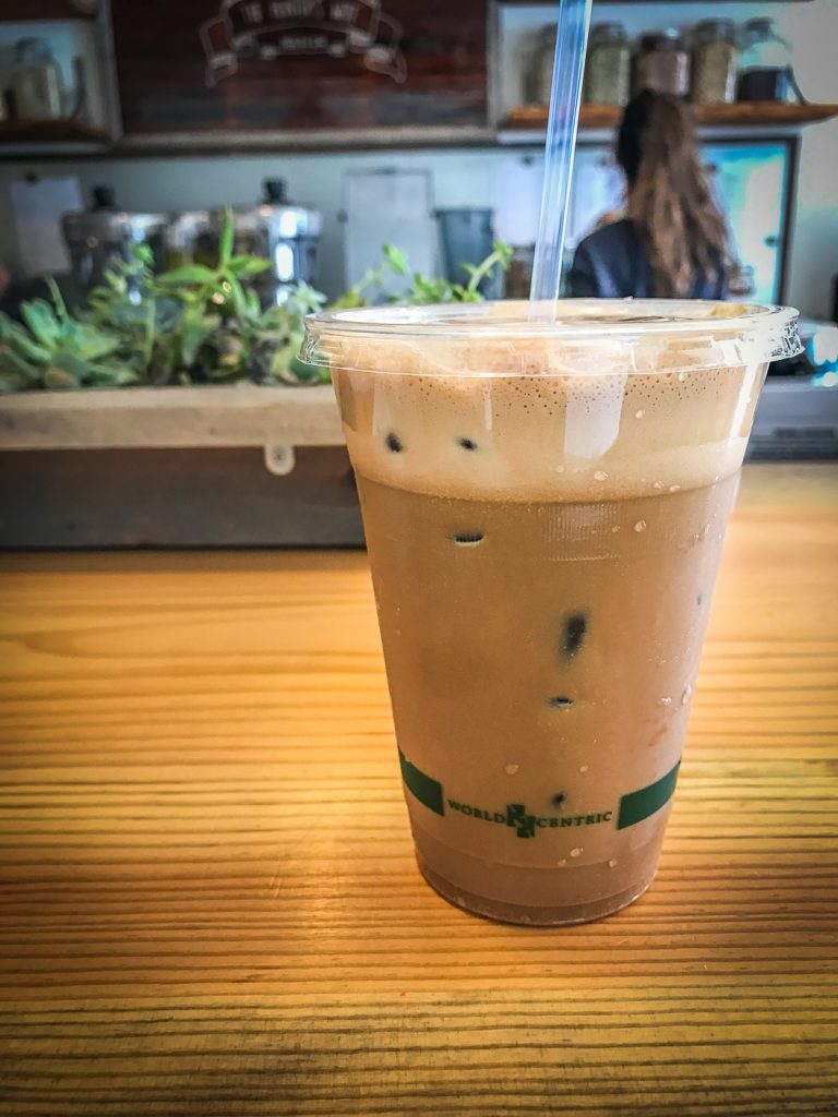 An iced coffee drink sitting on a wooden bar