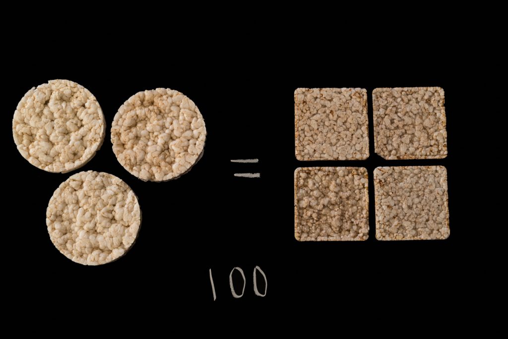 3 round rice cakes and 4 square rice cakes over the number 100 on a black background