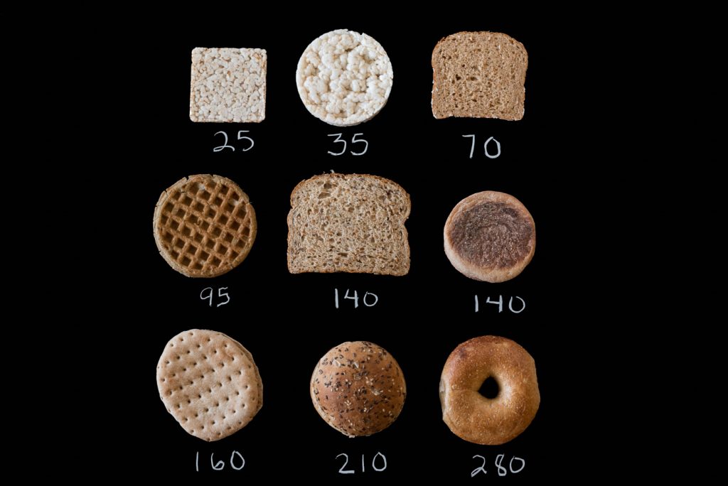 Black background with 9 different breads laid out with calorie values
