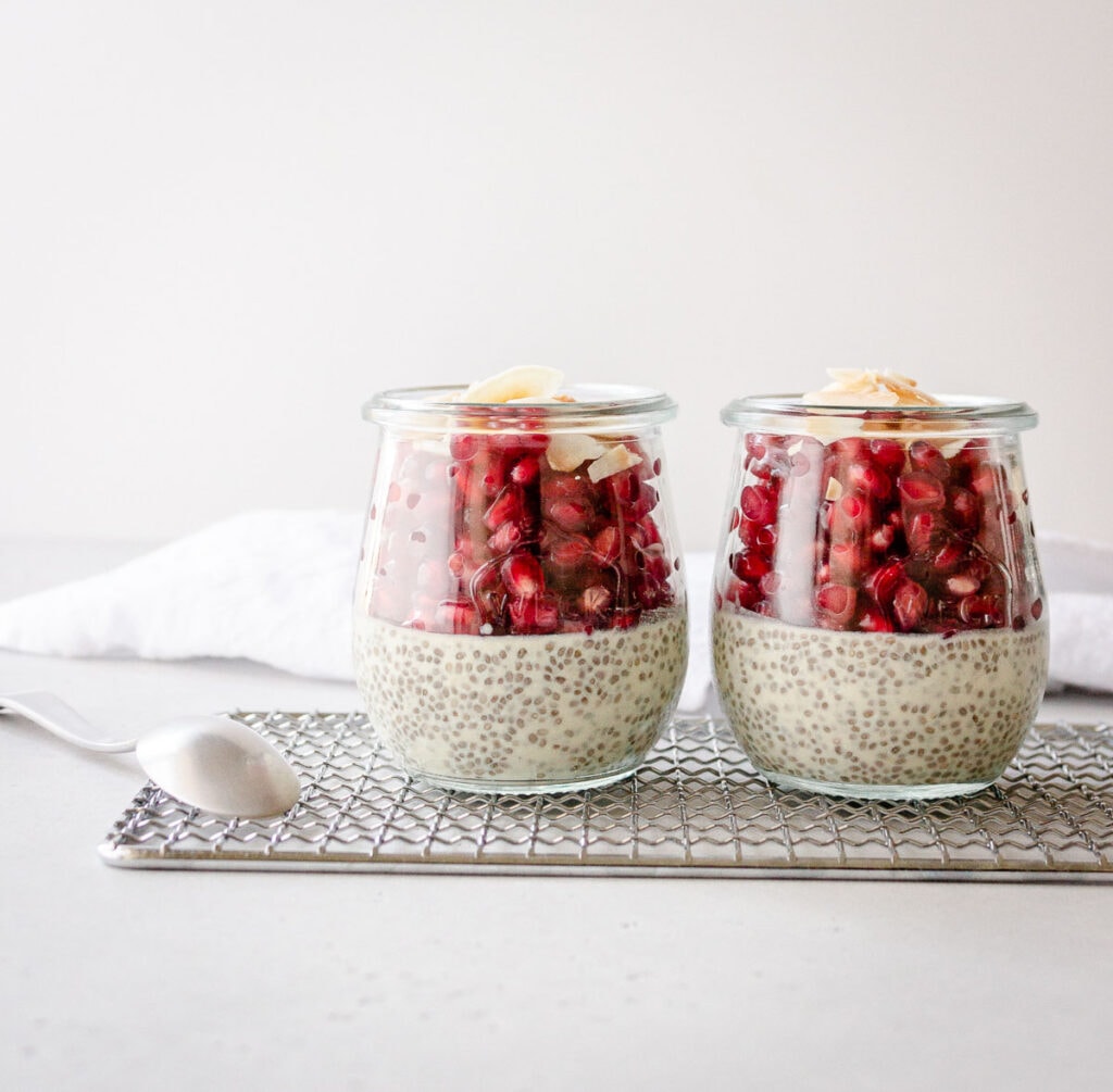 Side view of two small jars filled with pudding and fruit