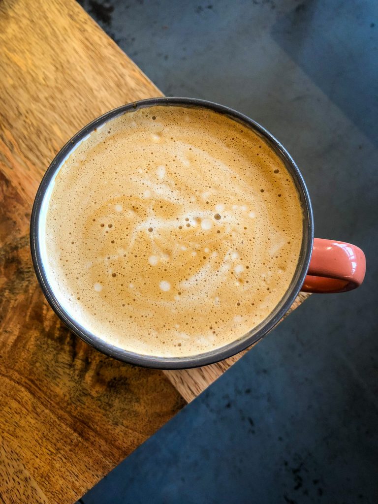 Coffee mug on the corner of a table topped with foam