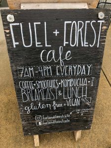 Chalkboard sandwich board sign with Fuel + Forest written on it