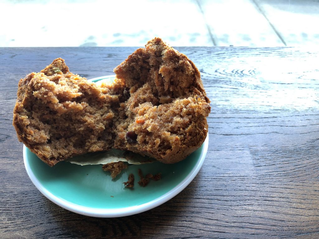 Turquoist plate with a muffin on it, torn in half