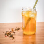 Glass filled with iced tea and a straw on a counter