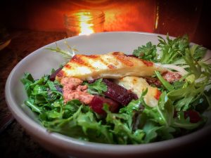 Bowl of salad with beets and grilled haloumi cheese