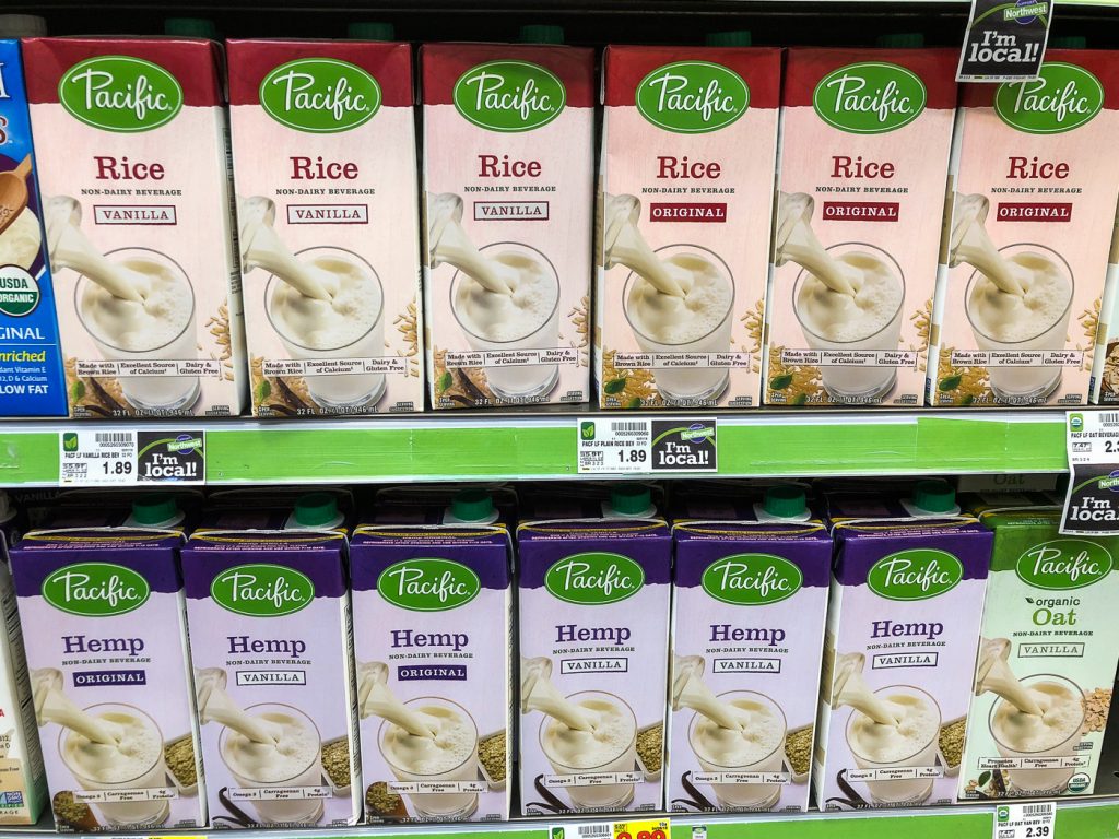 Grocery store shelf of boxes of rice and hemp milk