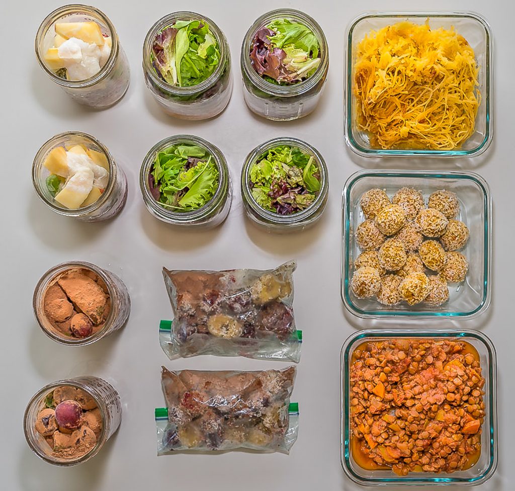 Overhead shot of mason jars and glass containers with salad and smoothie ingredients