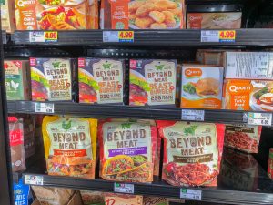 Freezer shelf in a grocery store with packages of meat substitutes