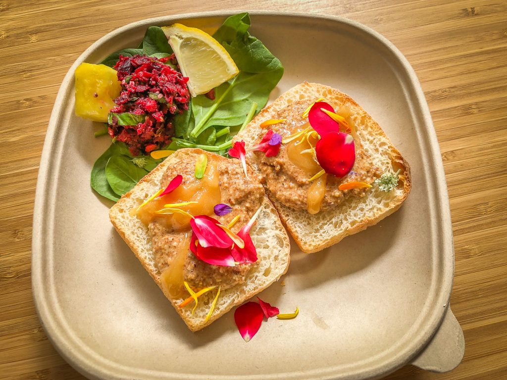 Top down shot of two pieces of toast with almond butter and honey and edible flowers