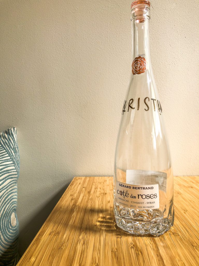 Glass bottle on bamboo table that has the name Kristine written on it