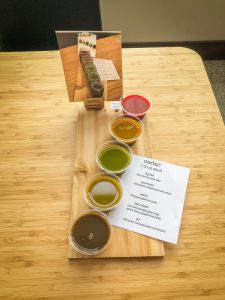 5 small cups of colorful juice on a cedar plank