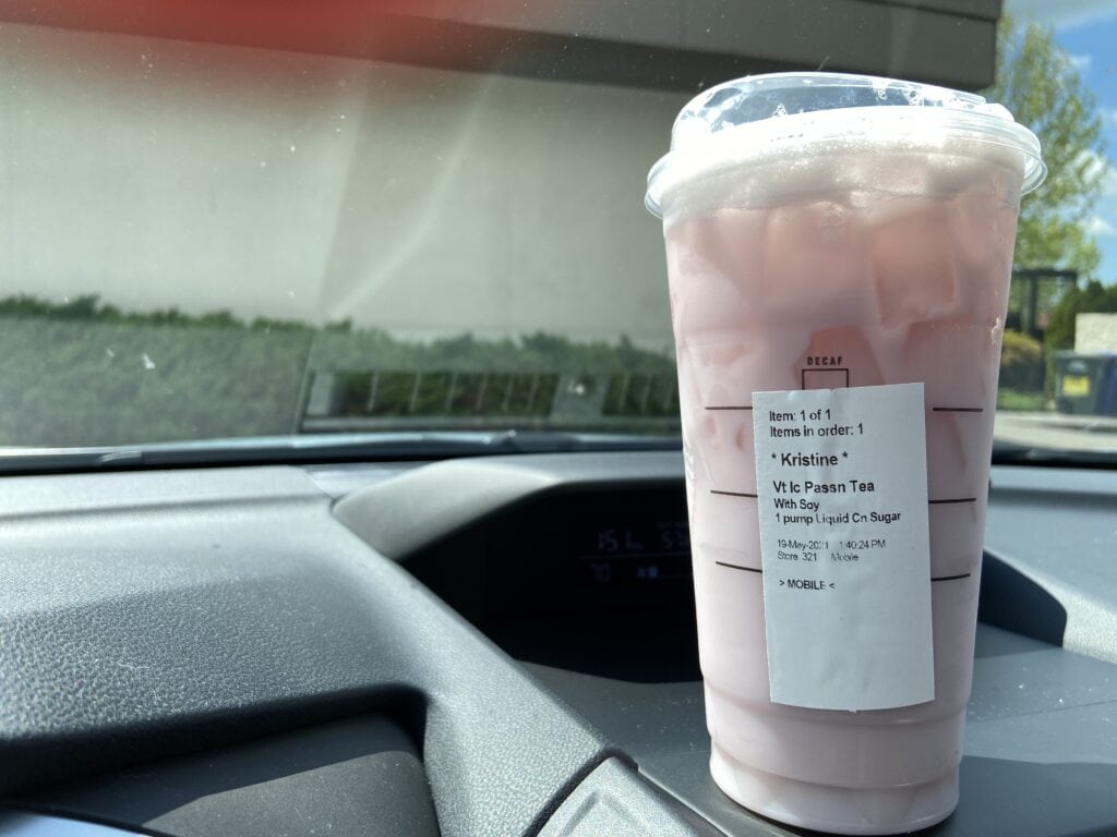Cup of Starbucks iced tea on the dash of a car