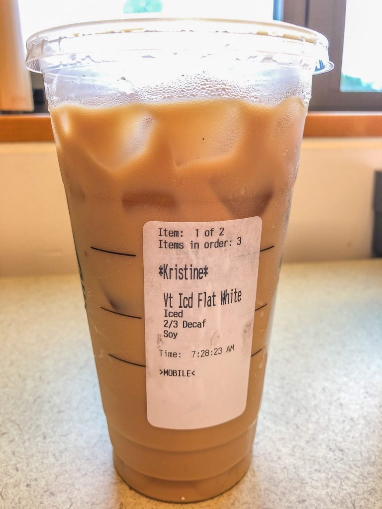 Starbucks cup with order sticker flat white
