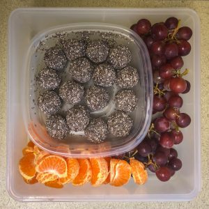 Plastic container filled with brownie bites and fruit