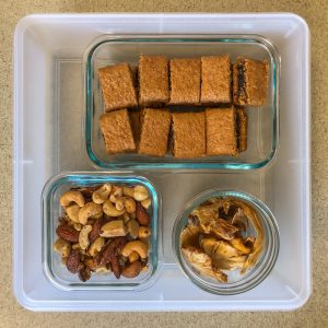 Plastic container with fig bars, nuts and dried fruit