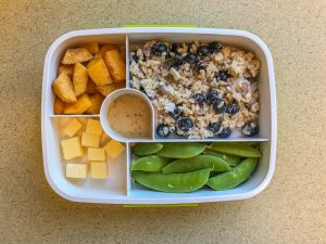 Plastic bento box filled with fruit and veggies