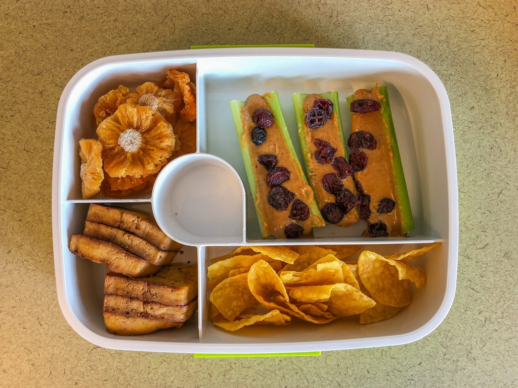 Plastic bento box filled with tofu and celery