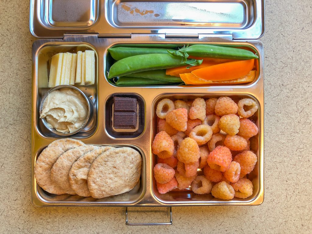 Metal lunch box filled with fruit and veggies