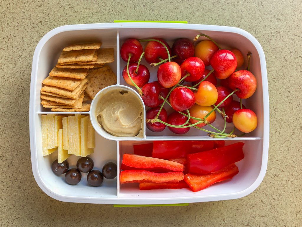 Plastic bento lunch box filled with fruit and veggies