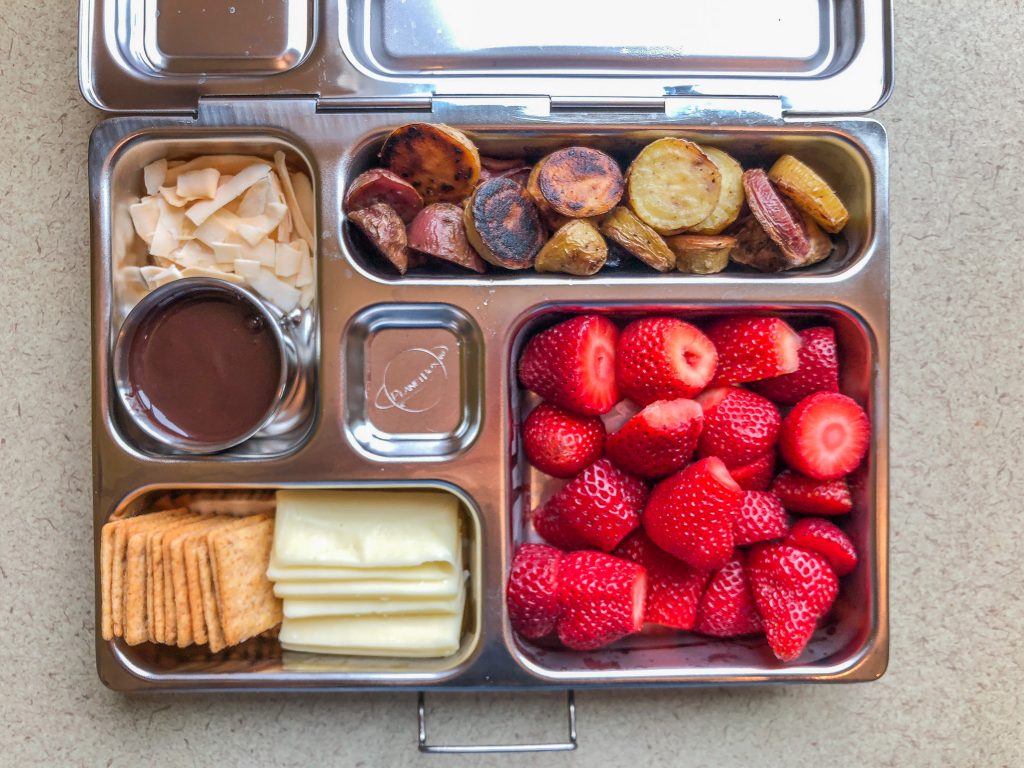 Metal lunchbox filled with fruit and veggies