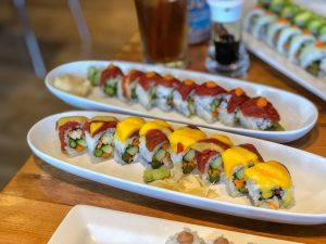 Two oval plates filled with colorful sushi rolls