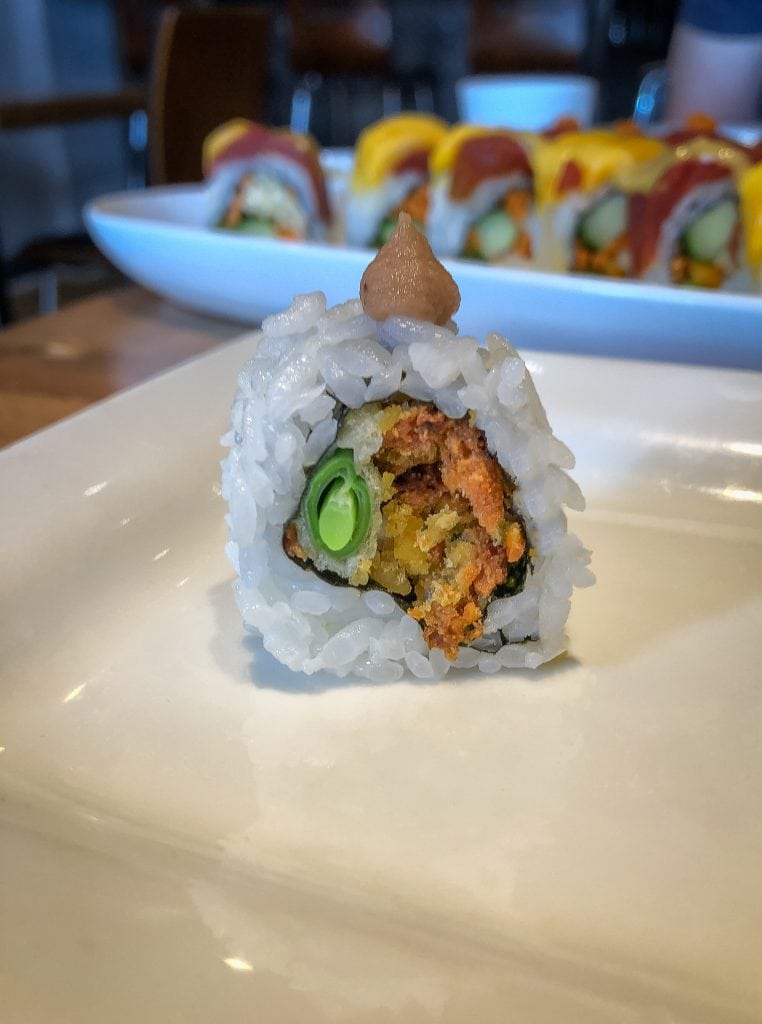 Close up picture of a sushi roll with falafel inside