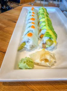 Oblong white plate with two rows of sushi rolls