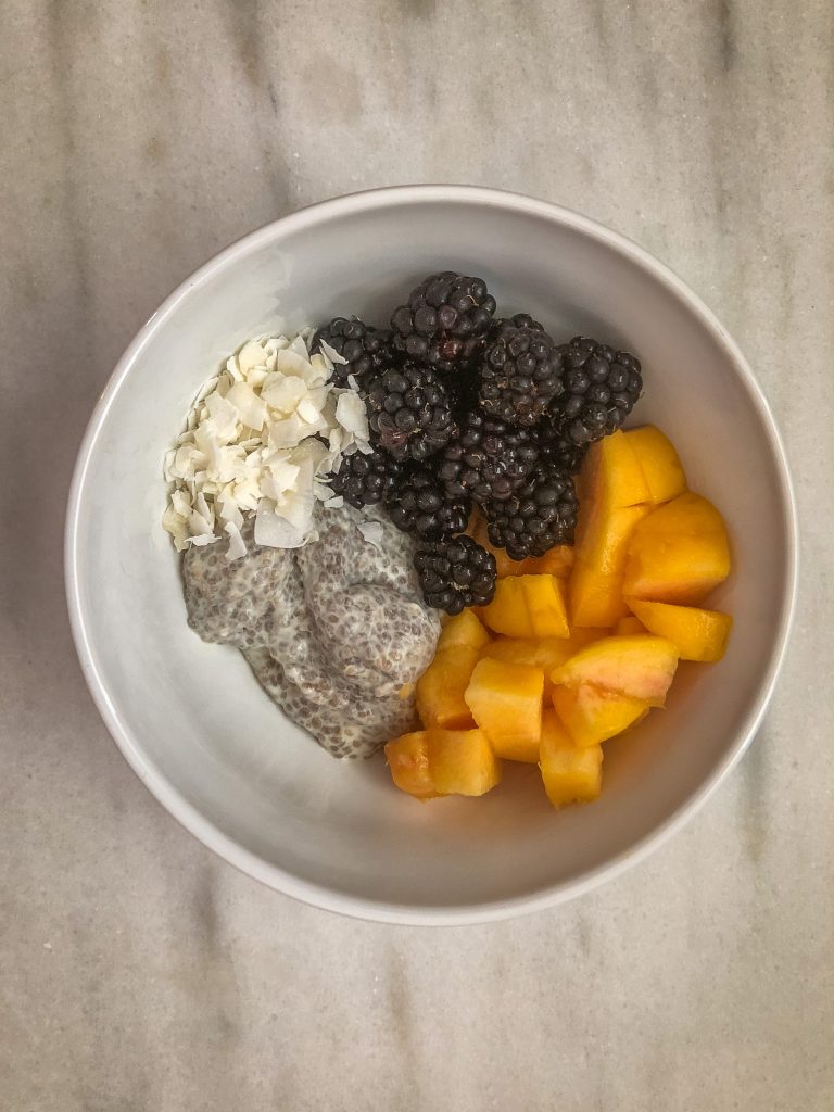 Bowl of chia pudding topped with fruit and coconut