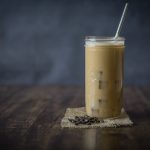 Mason jar filled with iced coffee and a straw