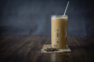 Mason jar filled with iced coffee and a straw