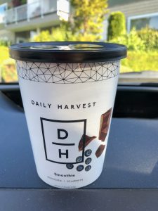 Paper cup on car dashboard with smoothie inside