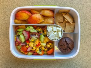 Bento box filled with fruit, crackers and vegetables