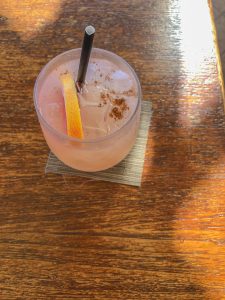 Tropical grapefruit drink in glass with straw and garnish