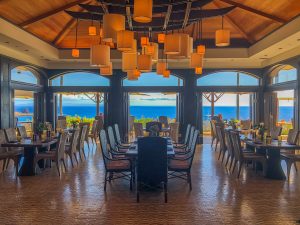 Tables and chairs in a restaurant with an ocean view