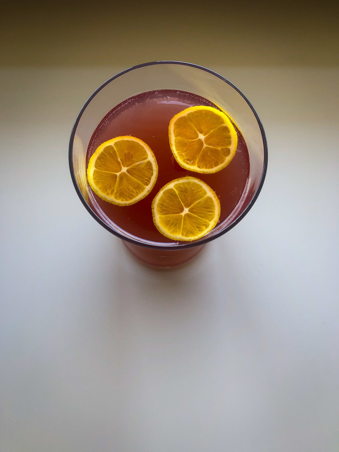 Top down shot of a glass with lemon slices floating in it