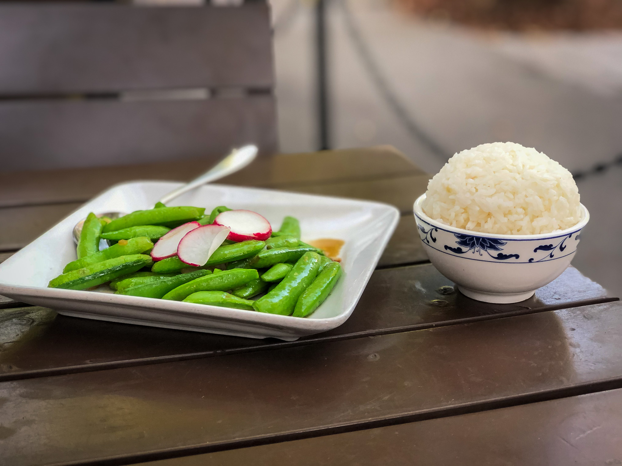Plate of snap peas and a bowl of white rice
