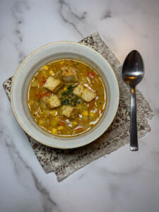 Top down picture of a bowl of soup with a spoon and napkin