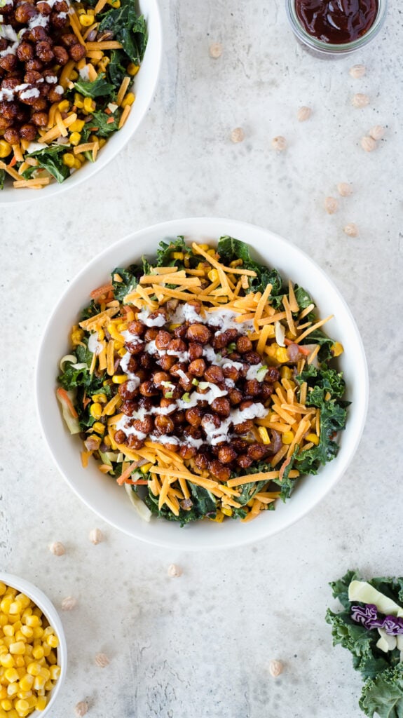 Top down view of white bowl full of kale, cheese, and chickpeas