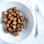 Bowl filled with tofu, napkin, fork