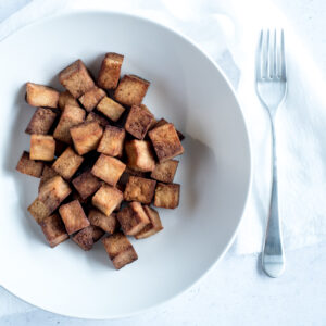 Bowl filled with tofu, napkin, fork