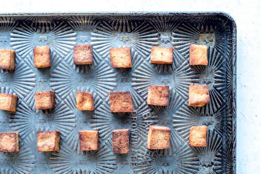 Cubes of baked tofu on a baking sheet