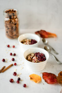 Two bowls of hot cereal and a jar of pecans