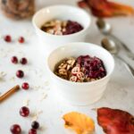 Two bowls of hot cereal surrounded by fall leaves and cinnamon sticks