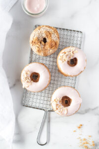 Top down view of 3 pink donuts and a streusel donut