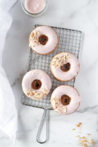 Top down view of 4 frosted donuts on a cooling rack