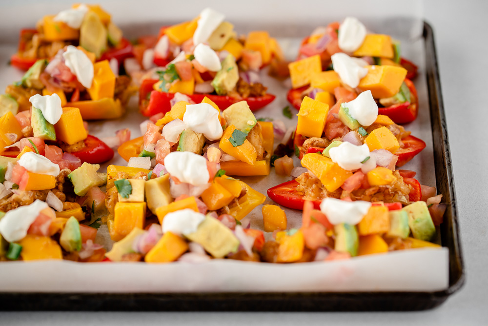 Pan full of mini pepper nachos with sour cream